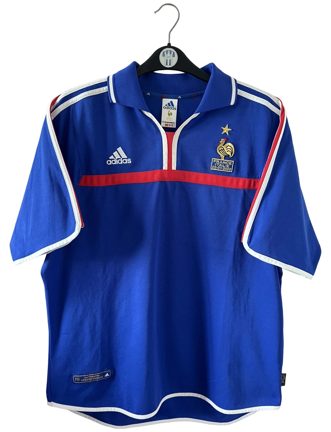 Maillot de foot vintage domicile bleu de l'Equipe de France 2000. On peut retrouver l'équipementier Adidas. Le maillot est floqué du numéro 10 Zinedine Zidane. Il s'agit d'un maillot authentique d'époque comportant la mention France-Italie 02-07-2000.