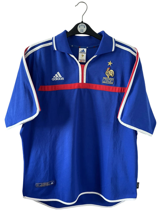 Maillot de foot vintage domicile bleu de l'Equipe de France 2000. On peut retrouver l'équipementier Adidas. Le maillot est floqué du numéro 10 Zinedine Zidane. Il s'agit d'un maillot authentique d'époque comportant la mention France-Italie 02-07-2000.