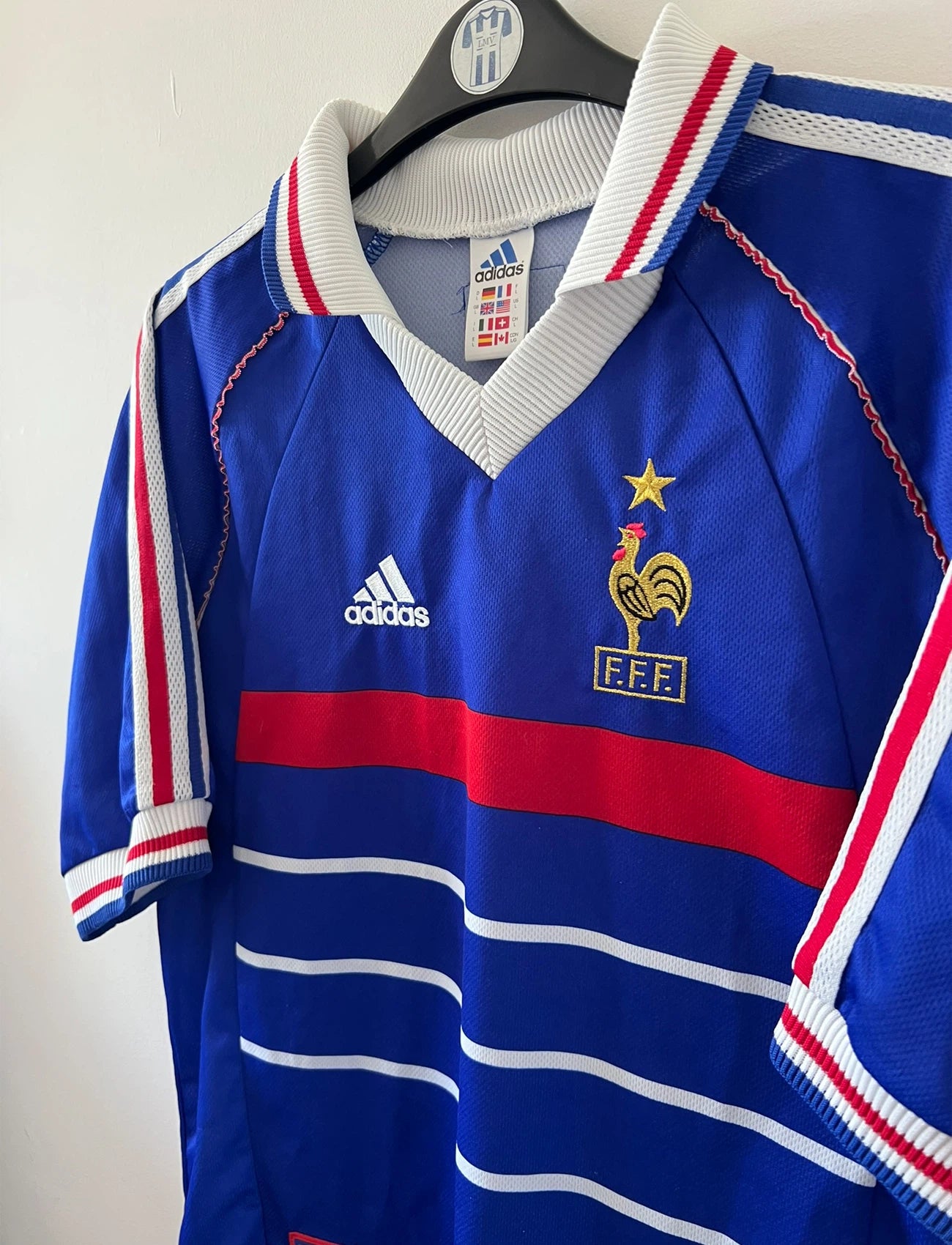 Maillot foot vintage domicile equipe de france 1998 bleu blanc et rouge. On peut retrouver l'équipementier adidas. Il s'agit d'un maillot authentique d'époque. Le maillot est floqué du numéro 10 Zinedine Zidane et comporte également sa signature avec la mention "pour toi Zinedine Zidane"