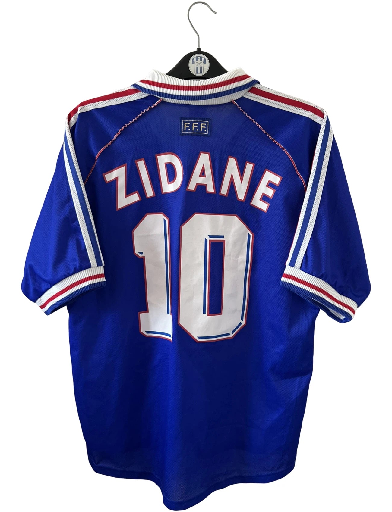 Maillot foot vintage domicile equipe de france 1998 bleu blanc et rouge. On peut retrouver l'équipementier adidas. Il s'agit d'un maillot authentique d'époque. Le maillot est floqué du numéro 10 Zinedine Zidane et comporte également sa signature avec la mention "pour toi Zinedine Zidane"