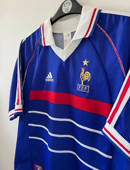 Maillot foot vintage domicile equipe de france 1998 bleu blanc et rouge. On peut retrouver l'équipementier adidas. Il s'agit d'un maillot authentique d'époque. Le maillot est floqué du numéro 10 Zinedine Zidane