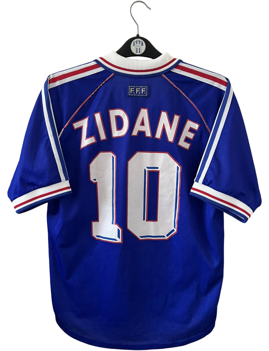 Maillot foot vintage domicile equipe de france 1998 bleu blanc et rouge. On peut retrouver l'équipementier adidas. Il s'agit d'un maillot authentique d'époque. Le maillot est floqué du numéro 10 Zinedine Zidane