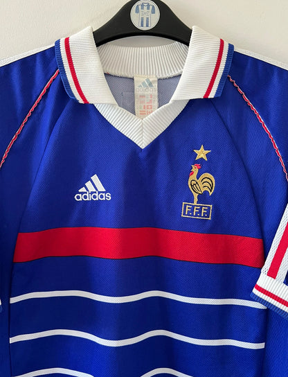 Maillot foot vintage domicile equipe de france 1998 bleu blanc et rouge. On peut retrouver l'équipementier adidas. Il s'agit d'un maillot authentique d'époque. Le maillot est floqué du numéro 10 Zinedine Zidane