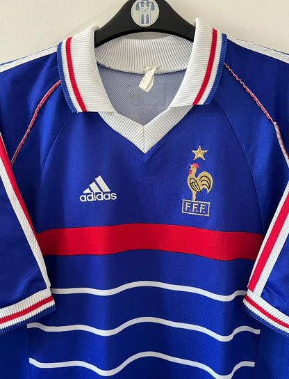 Maillot foot vintage domicile equipe de france 1998 bleu blanc et rouge. On peut retrouver l'équipementier adidas. Il s'agit d'un maillot authentique d'époque. Le maillot est floqué du numéro 10 Zinedine Zidane