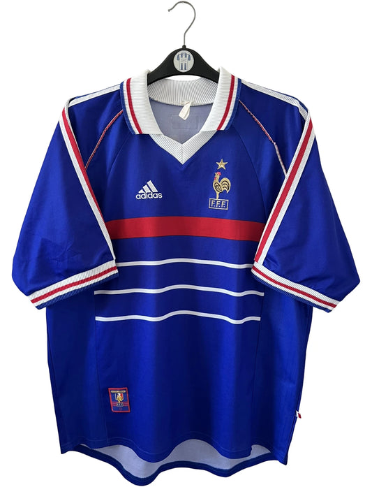 Maillot foot vintage domicile equipe de france 1998 bleu blanc et rouge. On peut retrouver l'équipementier adidas. Il s'agit d'un maillot authentique d'époque. Le maillot est floqué du numéro 10 Zinedine Zidane