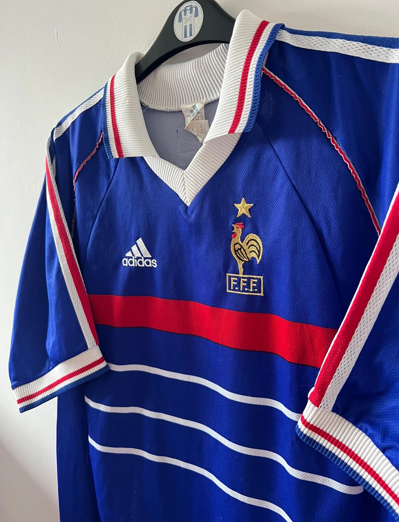 Maillot foot vintage domicile equipe de france 1998 bleu blanc et rouge. On peut retrouver l'équipementier adidas. Il s'agit d'un maillot authentique d'époque. Le maillot est floqué du numéro 10 Zinedine Zidane et comporte également sa signature avec la mention "pour toi Zinedine Zidane"