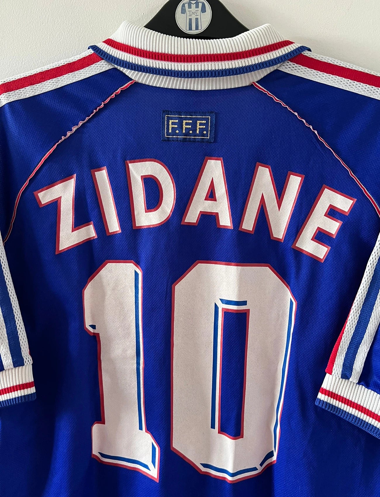 Maillot foot vintage domicile equipe de france 1998 bleu blanc et rouge. On peut retrouver l'équipementier adidas. Il s'agit d'un maillot authentique d'époque. Le maillot est floqué du numéro 10 Zinedine Zidane et comporte également sa signature avec la mention "pour toi Zinedine Zidane"