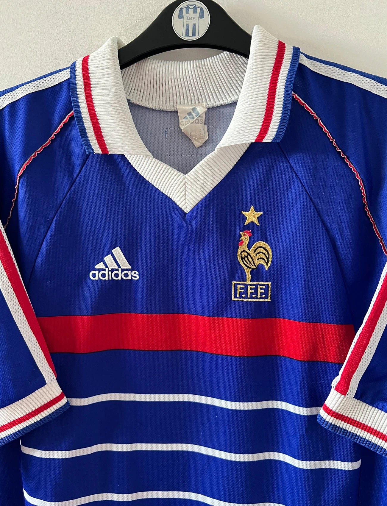 Maillot foot vintage domicile equipe de france 1998 bleu blanc et rouge. On peut retrouver l'équipementier adidas. Il s'agit d'un maillot authentique d'époque. Le maillot est floqué du numéro 10 Zinedine Zidane et comporte également sa signature avec la mention "pour toi Zinedine Zidane"