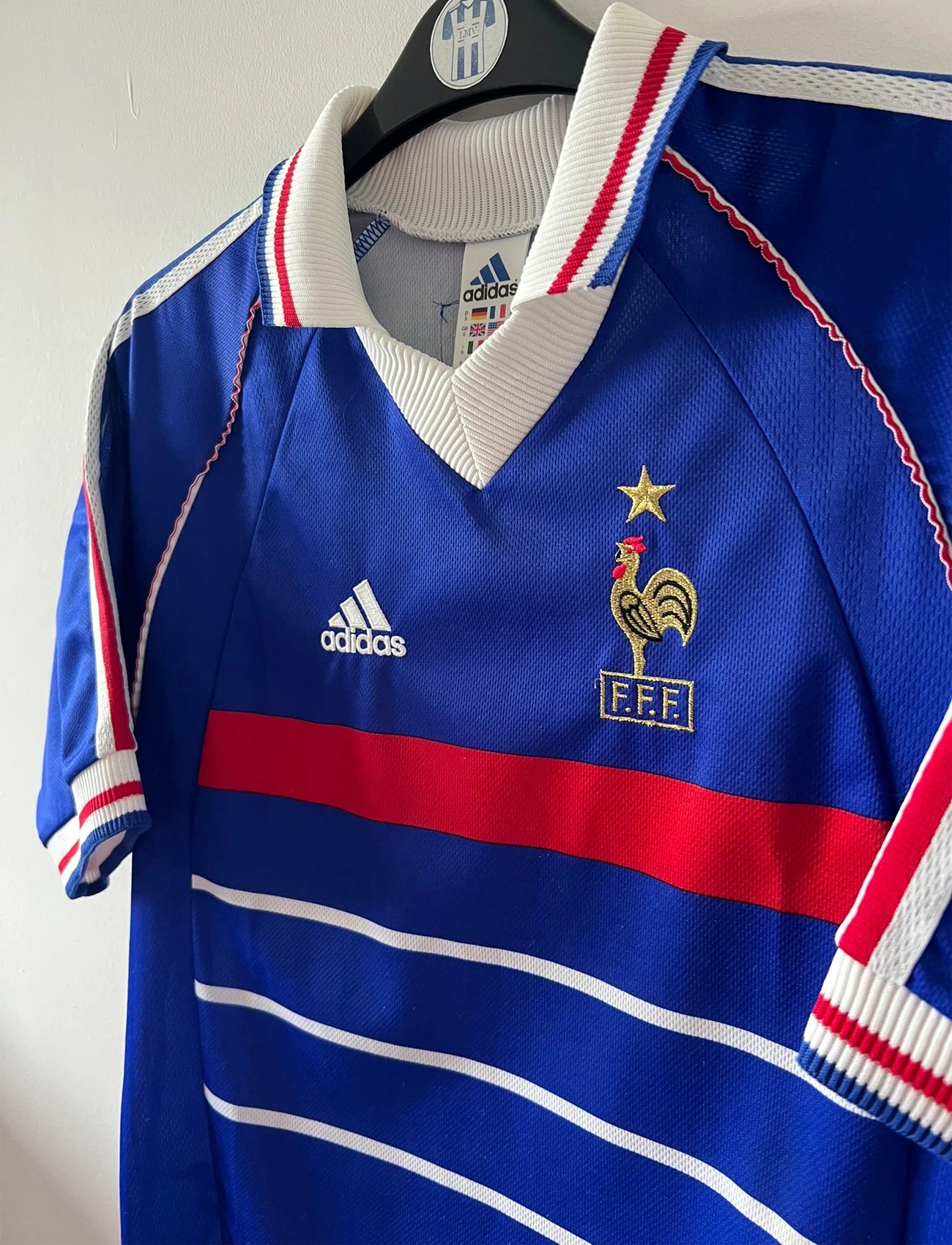 Maillot foot vintage domicile equipe de france 1998 bleu blanc et rouge. On peut retrouver l'équipementier adidas. Il s'agit d'un maillot authentique d'époque. Le maillot est floqué du numéro 10 Zinedine Zidane et comporte également sa signature avec la mention "pour toi Zinedine Zidane"