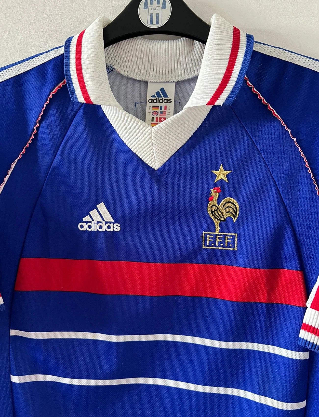 Maillot foot vintage domicile equipe de france 1998 bleu blanc et rouge. On peut retrouver l'équipementier adidas. Il s'agit d'un maillot authentique d'époque. Le maillot est floqué du numéro 10 Zinedine Zidane et comporte également sa signature avec la mention "pour toi Zinedine Zidane"