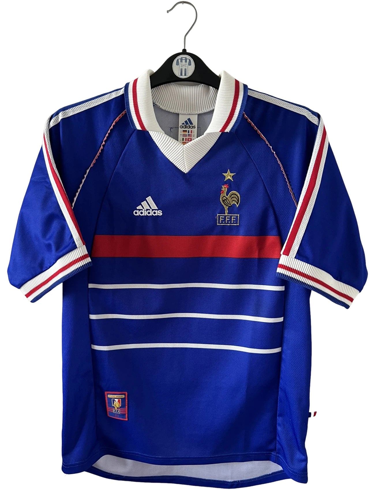 Maillot foot vintage domicile equipe de france 1998 bleu blanc et rouge. On peut retrouver l'équipementier adidas. Il s'agit d'un maillot authentique d'époque. Le maillot est floqué du numéro 10 Zinedine Zidane et comporte également sa signature avec la mention "pour toi Zinedine Zidane"