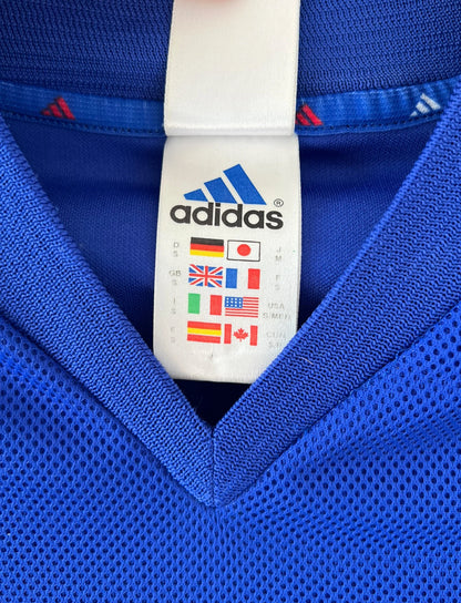 Maillot de foot vintage domicile bleu de l'équipe de france 2002. On peut retrouver l'équipementier Adidas et le flocage de Zidane. Il s'agit d'un maillot authentique d'époque.