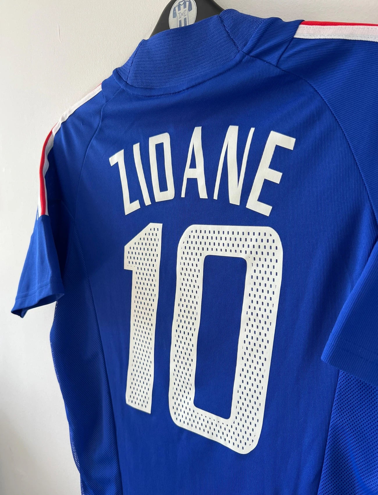 Maillot de foot vintage domicile bleu de l'équipe de france 2002. On peut retrouver l'équipementier Adidas et le flocage de Zidane. Il s'agit d'un maillot authentique d'époque.