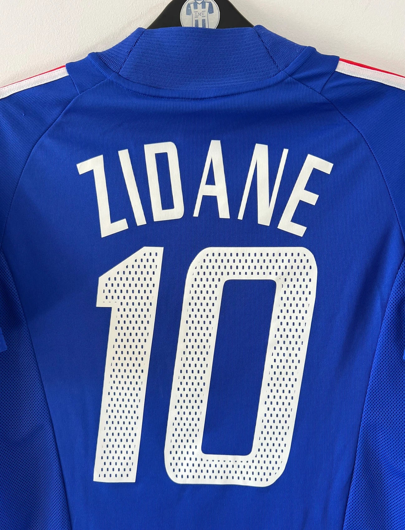 Maillot de foot vintage domicile bleu de l'équipe de france 2002. On peut retrouver l'équipementier Adidas et le flocage de Zidane. Il s'agit d'un maillot authentique d'époque.