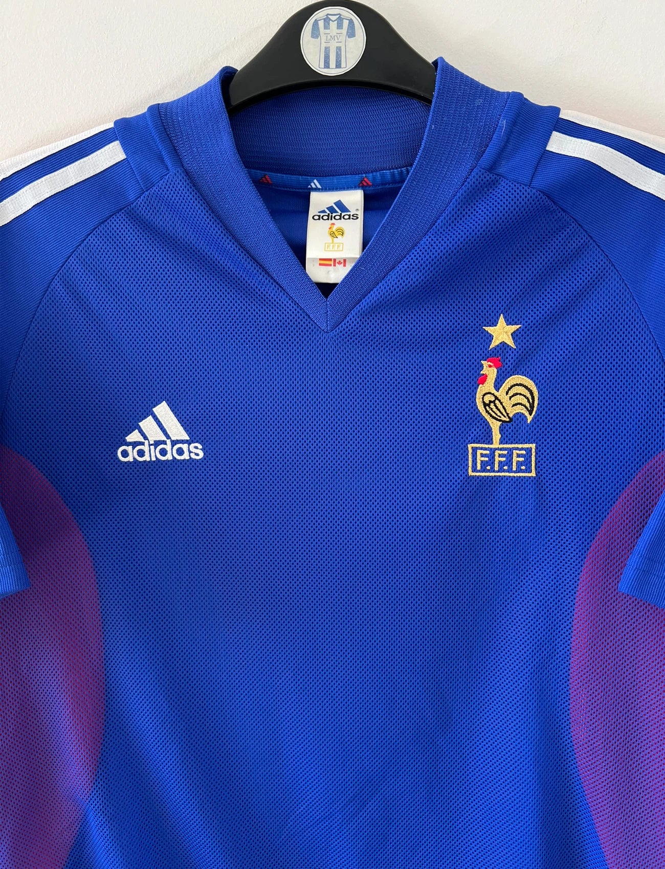 Maillot de foot vintage domicile bleu de l'équipe de france 2002. On peut retrouver l'équipementier Adidas et le flocage de Zidane. Il s'agit d'un maillot authentique d'époque.