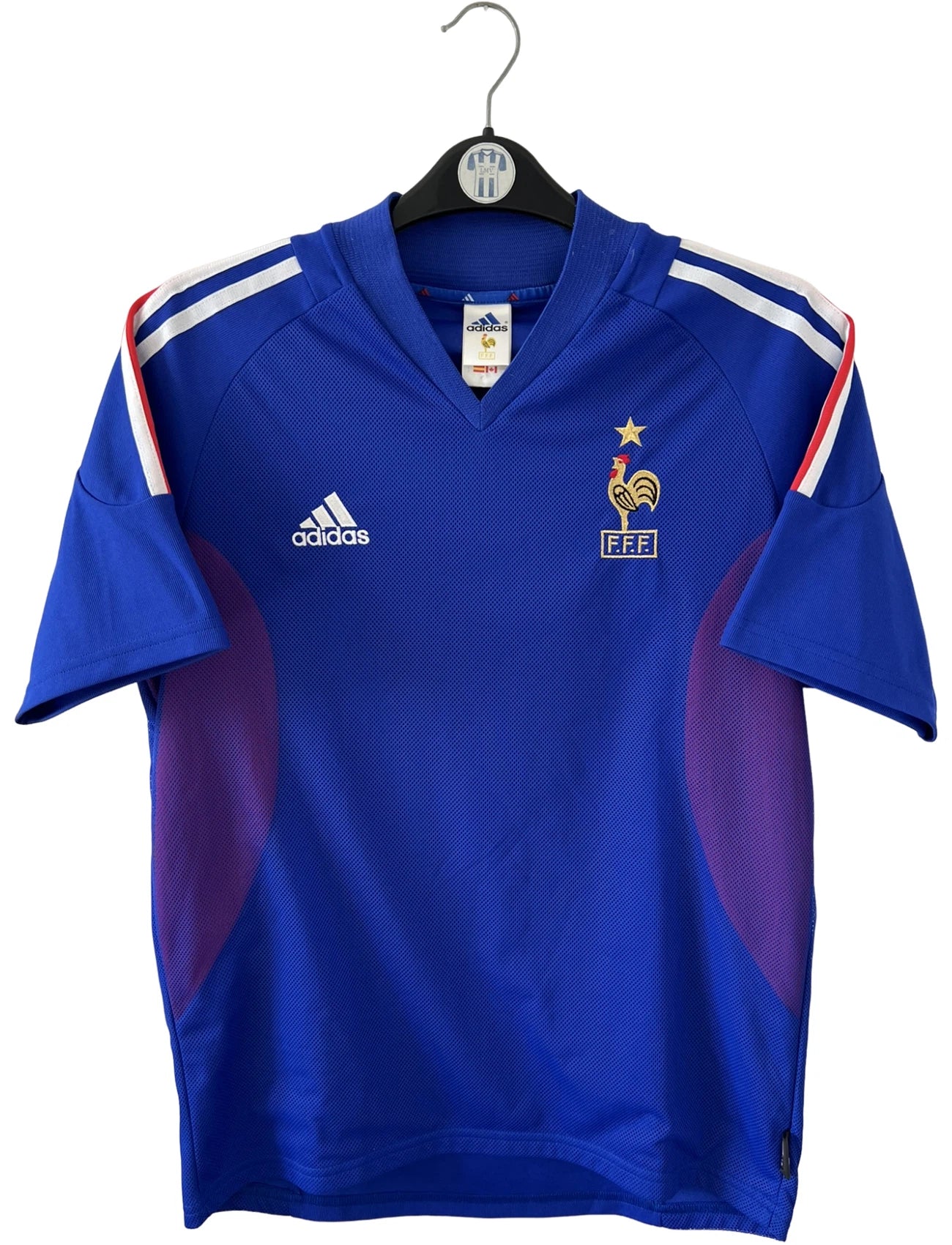 Maillot de foot vintage domicile bleu de l'équipe de france 2002. On peut retrouver l'équipementier Adidas et le flocage de Zidane. Il s'agit d'un maillot authentique d'époque.