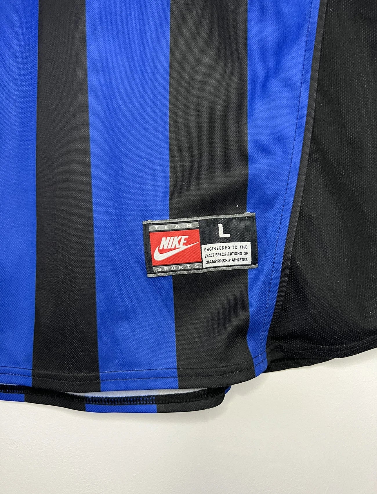 Maillot de foot vintage domicile bleu et noir de l'Inter Milan de la saison 1998/1999. On peut retrouver l'équipementier Nike et le sponsor Pirelli. Le maillot est floqué du numéro 9 Ronaldo. Il s'agit d'un maillot authentique d'époque.