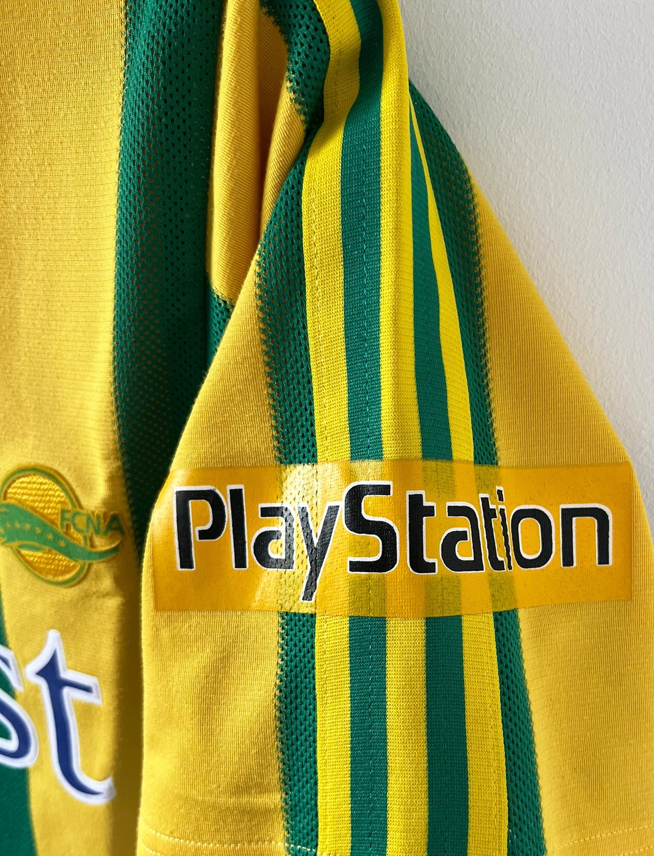 Maillot de foot vintage domicile jaune et vert du FC Nantes 1996/1997. On peut retrouver l'équipementier Adidas et le sponsor Eurest et Playstation. Il s'agit d'un maillot authentique d'époque.