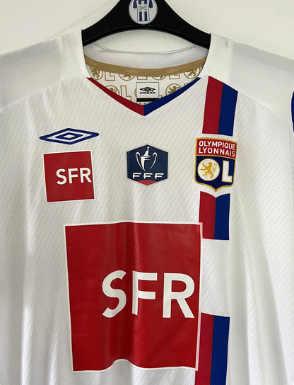 Maillot de foot vintage domicile blanc de l'OL de la saison 2007-2008. Il s'agit de l'édition coupe de france. On peut retrouver l'équipementier Umbro, ainsi que les sponsors SFR et Pitch. Le maillot est floqué du numéro 5 Mathieu Bodmer. Il s'agit d'un maillot authentique d'époque.
