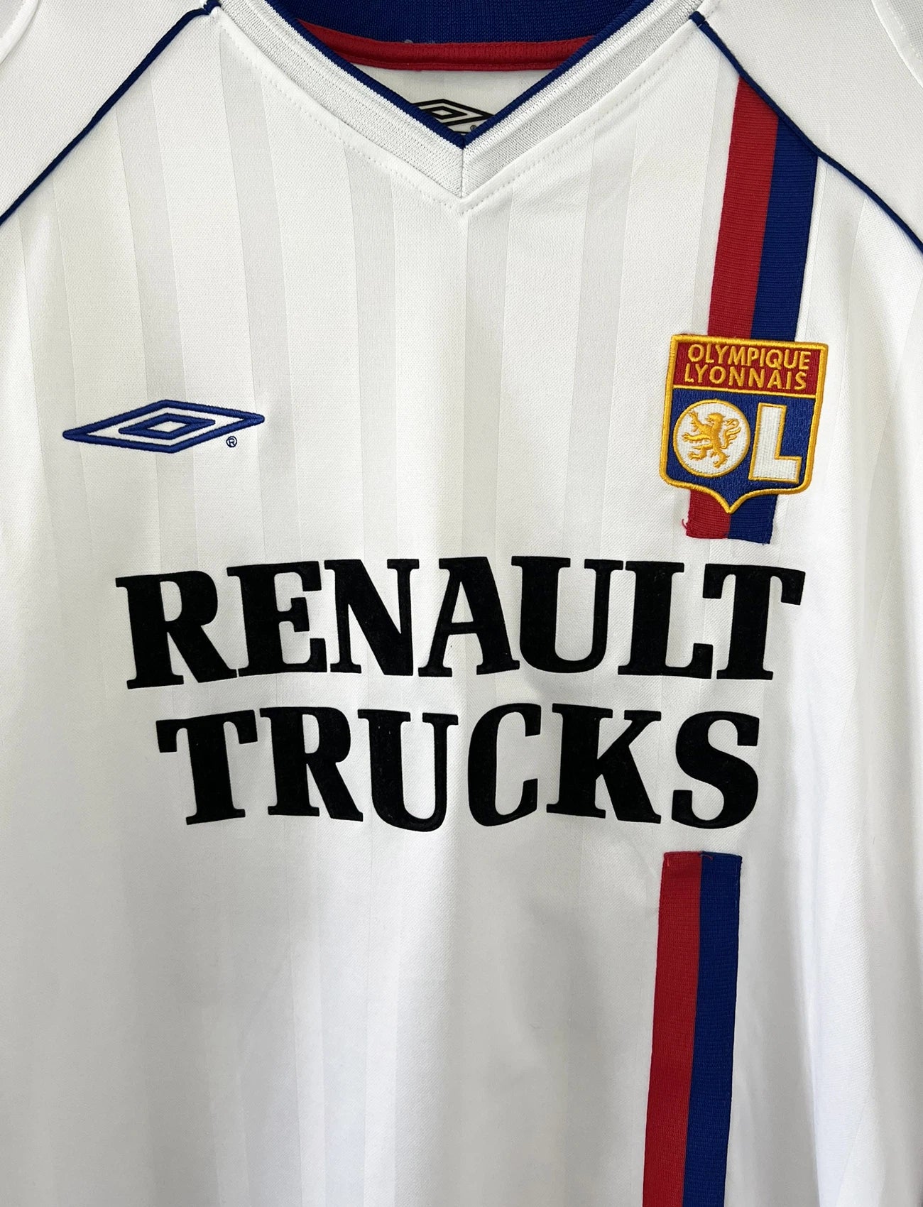 Maillot de foot vintage domicile de l'OL lors de la saison 2003/2004. Le maillot est de couleur blanc et bleu. On peut retrouver l'équipementier Umbro et le sponsor Renault Trucks. Le maillot est floqué du numéro 24 Vikash Dhorasoo. Il s'agit d'un maillot authentique