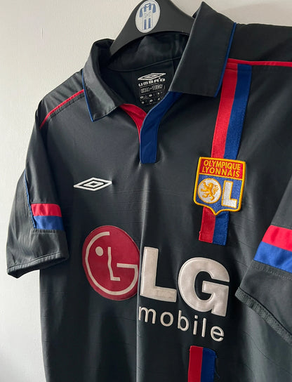 Maillot foot vintage extérieur noir de l'OL 2004/2005. On peut retrouver l'équipementier Umbro et le sponsor LG. Il s'agit d'un maillot authentique d'époque.