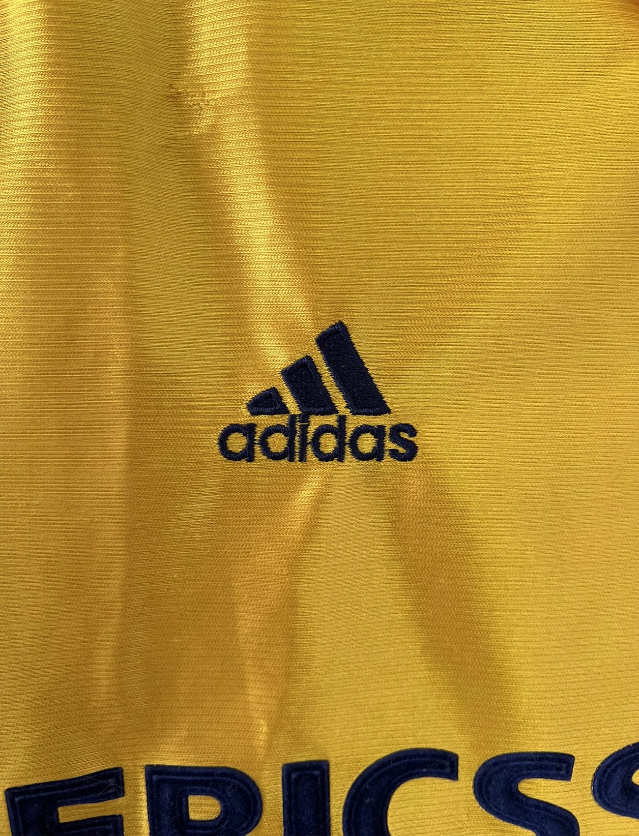 Maillot de foot vintage third de l'OM de la saison 1998-1999. Il s'agit du maillot édité pour le centenaire du club. Le maillot est de couleur dorée et bleu. On peut retrouver l'équipementier adidas et le sponsor ericsson. Il s'agit d'un maillot authentique d'époque.