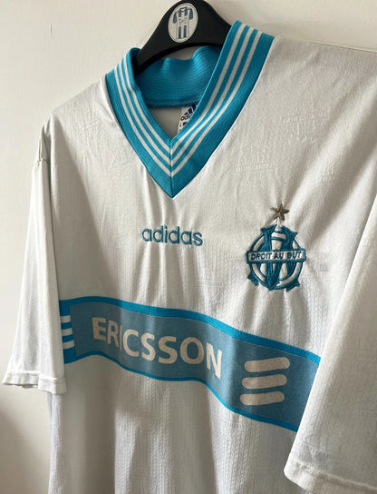 Maillot de foot vintage domicile blanc et bleu de l'OM 1997/1998. On peut retrouver l'équipementier Adidas et le sponsor Ericsson. Il s'agit d'un maillot authentique d'époque.