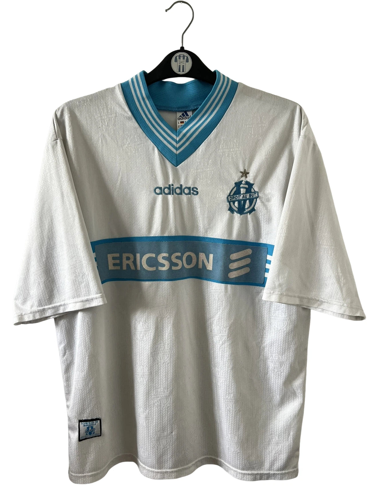 Maillot de foot vintage domicile blanc et bleu de l'OM 1997/1998. On peut retrouver l'équipementier Adidas et le sponsor Ericsson. Il s'agit d'un maillot authentique d'époque.
