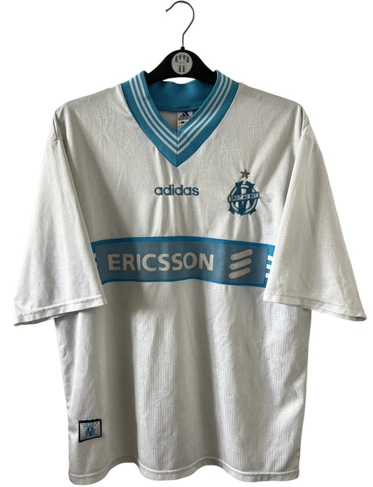 Maillot de foot vintage domicile blanc et bleu de l'OM 1997/1998. On peut retrouver l'équipementier Adidas et le sponsor Ericsson. Il s'agit d'un maillot authentique d'époque.