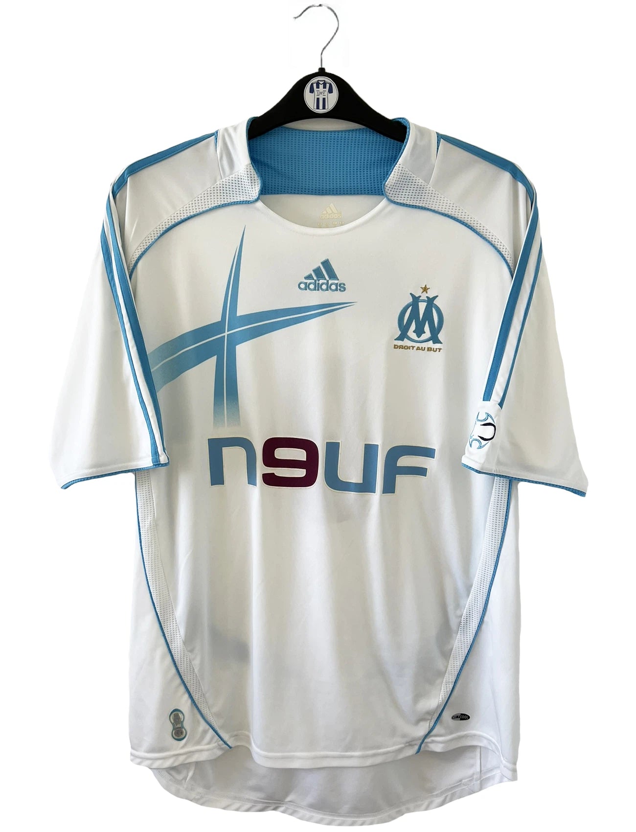 Maillot de foot vintage domicile de l'OM de la saison 2006/2007. Le maillot est de couleur blanc et bleu. On peut retrouver l'équipementier adidas et le sponsor Neuf. Le maillot est floqué du numéro 9 Djibril Cissé. Il s'agit d'un maillot authentique d'époque comportant les numéros 084929