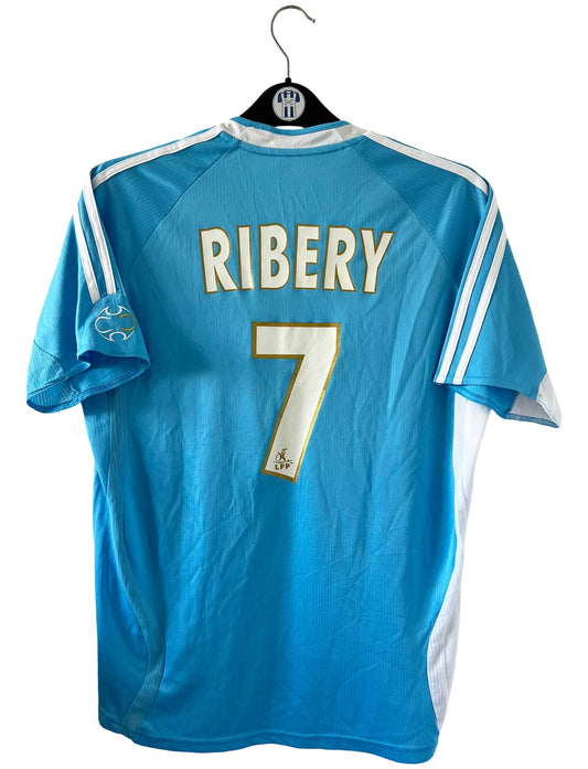 Maillot de foot vintage extérieur bleu et blanc de l'om de la saison 2006/2007. On peut retrouver l'équipementier Adidas et le sponsor Neuf. Le maillot est floqué du numéro  Franck Ribery. Il s'agit d'un maillot authentique d'époque.