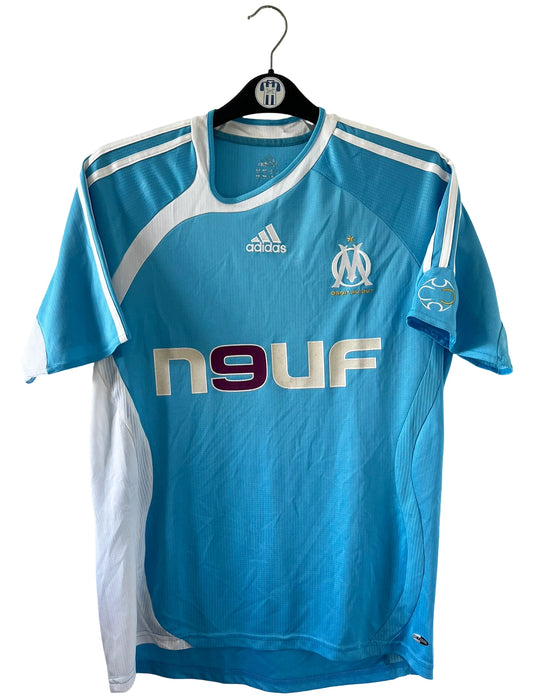 Maillot de foot vintage extérieur bleu et blanc de l'om de la saison 2006/2007. On peut retrouver l'équipementier Adidas et le sponsor Neuf. Le maillot est floqué du numéro  Franck Ribery. Il s'agit d'un maillot authentique d'époque.