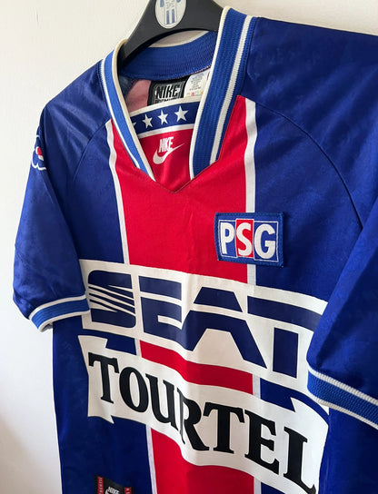 Maillot de foot vintage domicile bleu et rouge du PSG 1994/1995. On peut retrouver l'équipementier Nike et le sponsor SEAT et Tourtel. Il s'agit d'un maillot authentique d'époque.