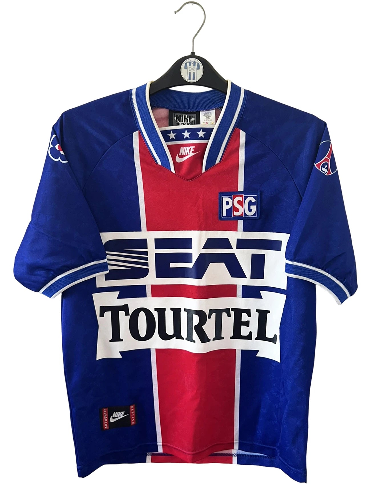 Maillot de foot vintage domicile bleu et rouge du PSG 1994/1995. On peut retrouver l'équipementier Nike et le sponsor SEAT et Tourtel. Il s'agit d'un maillot authentique d'époque.