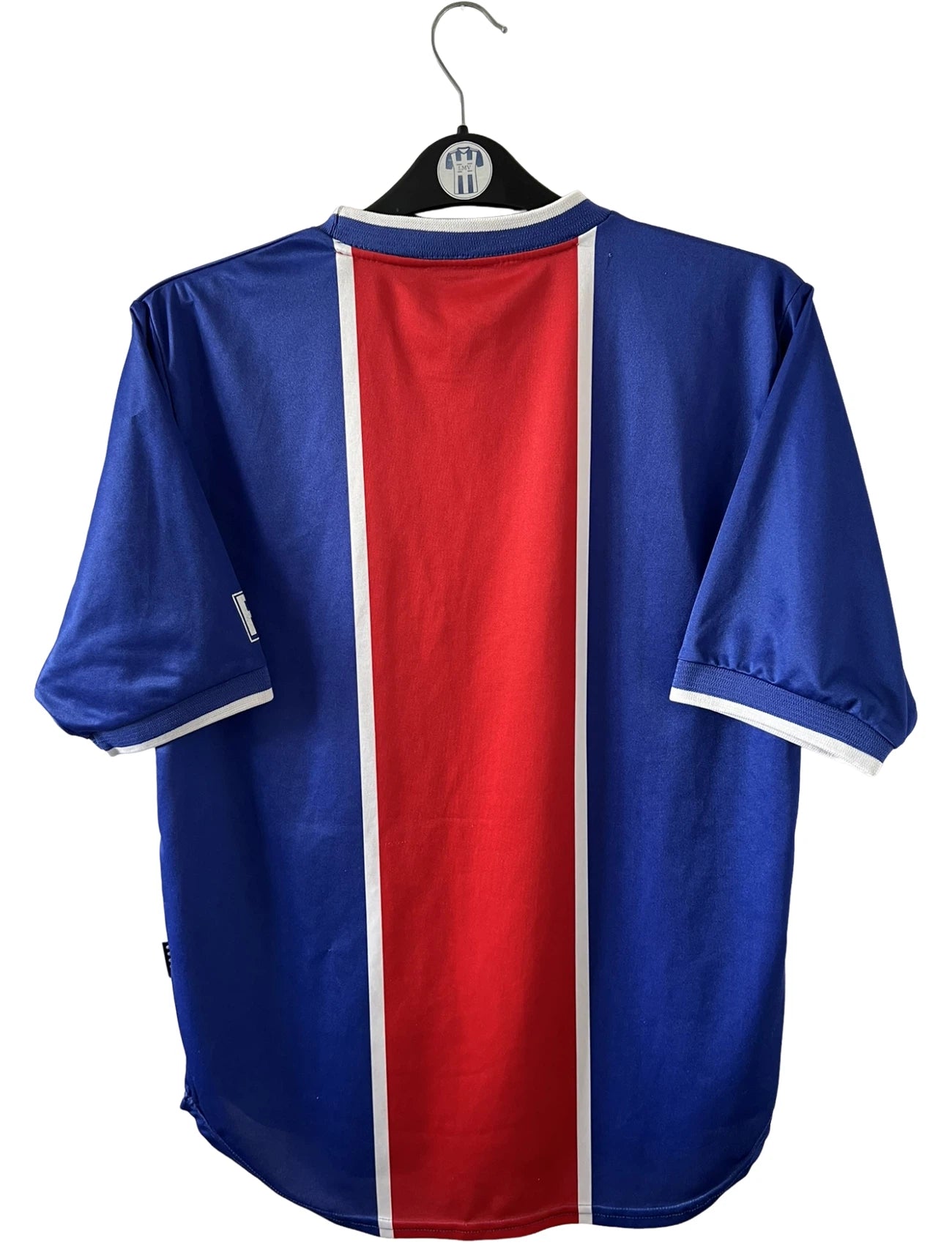 Maillot de foot vintage domicile rouge et bleu du PSG 1999/2000. On peut retrouver l'équipementier Nike et le sponsor Opel. Il s'agit d'un maillot authentique d'époque.