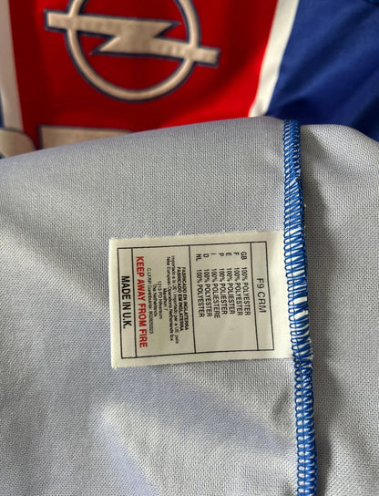 Maillot de foot vintage domicile blanc et rouge du PSG 1999/2000. On peut retrouver l'équipementier Nike et le sponsor Opel. Il s'agit d'un maillot authentique d'époque.