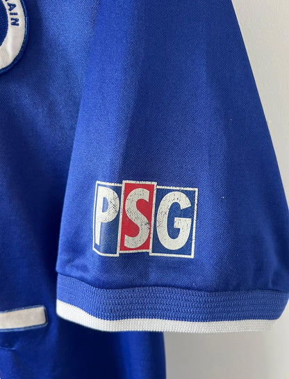 Maillot de foot vintage domicile rouge et bleu du PSG 1999/2000. On peut retrouver l'équipementier Nike et le sponsor Opel. Il s'agit d'un maillot authentique d'époque.