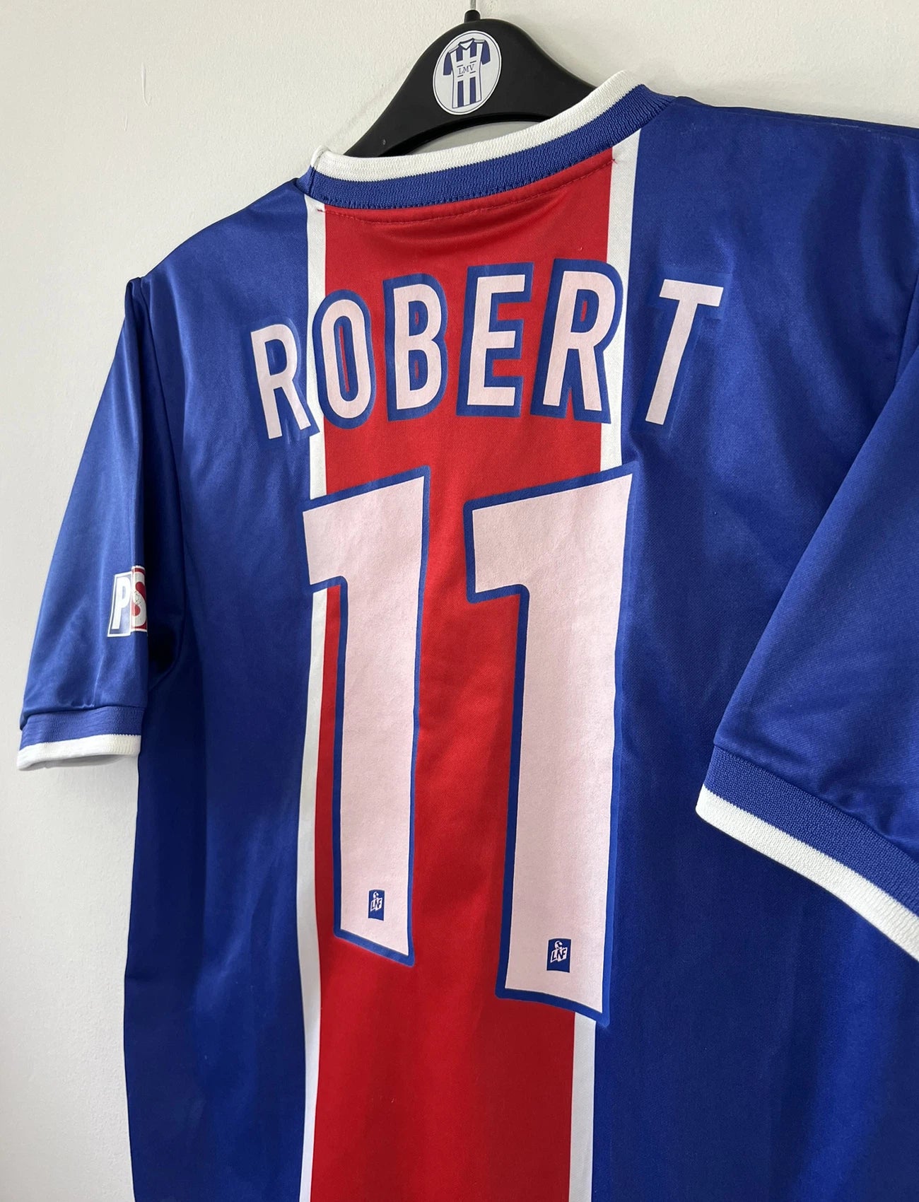 Maillot de foot vintage domicile du PSG de la saison 1999/2000. Le maillot est de couleur bleu et rouge. On peut retrouver l'équipementier nike et le sponsor Opel. Le maillot est floqué du numéro 11 Laurent Robert. Il s''agit d'un maillot authentique d'époque comportant l'étiquette avec les numéros F9 CRM