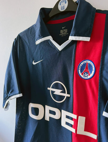 Maillot de foot vinage domicile bleu du PSG de la saison 2001/2002. On peut retrouver l'équipementier Nike et le sponsor Opel. Il s'agit d'un maillot authentique d'époque.