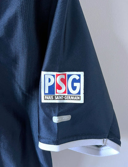 Maillot de foot vinage domicile bleu du PSG de la saison 2001/2002. On peut retrouver l'équipementier Nike et le sponsor Opel. Il s'agit d'un maillot authentique d'époque.