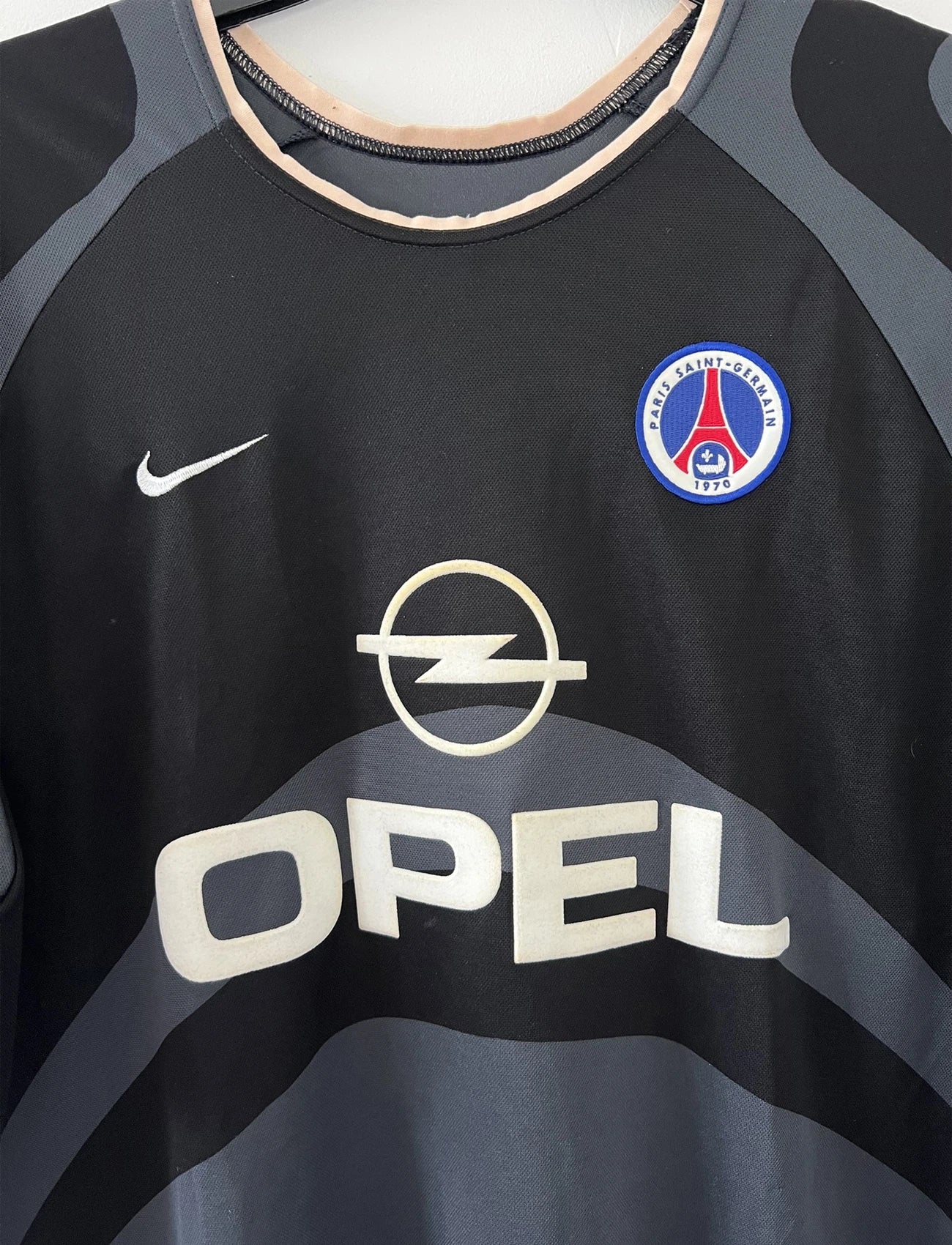 Maillot de foot vintage third du PSG 2001/2002. Le maillot est de couleur noir et gris. On peut retrouver l'équipementier nike et le sponsor Opel. Le maillot est floqué du numéro 5 Pochettino. Il s'agit d'un maillot authentique avec l'étiquette et les numéros F1AOG