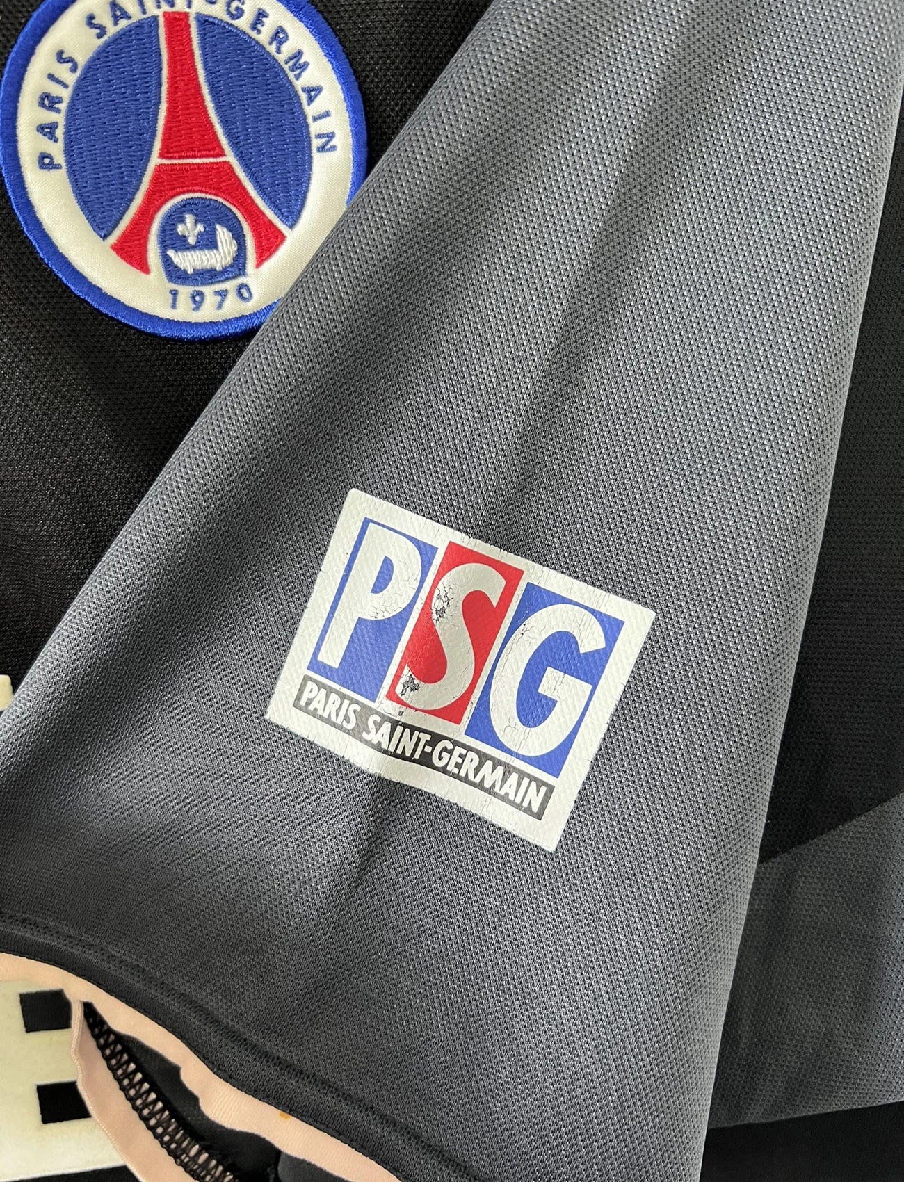Maillot de foot vintage third du PSG 2001/2002. Le maillot est de couleur noir et gris. On peut retrouver l'équipementier nike et le sponsor Opel. Le maillot est floqué du numéro 5 Pochettino. Il s'agit d'un maillot authentique avec l'étiquette et les numéros F1AOG