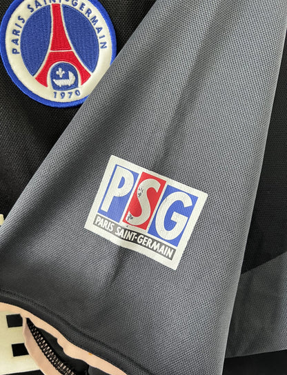 Maillot de foot vintage third du PSG 2001/2002. Le maillot est de couleur noir et gris. On peut retrouver l'équipementier nike et le sponsor Opel. Le maillot est floqué du numéro 5 Pochettino. Il s'agit d'un maillot authentique avec l'étiquette et les numéros F1AOG