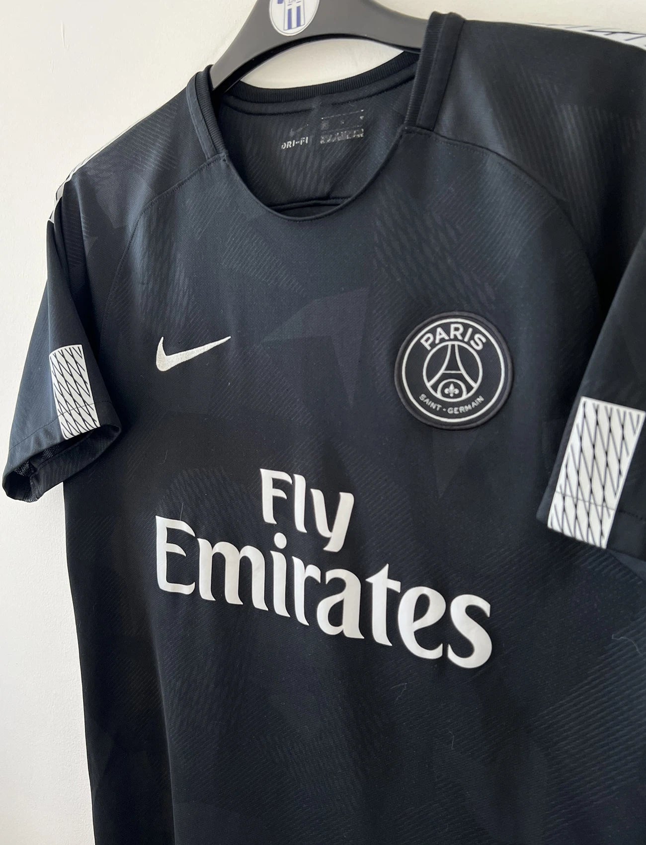 Maillot de foot vintage du PSG third de la saison 2017/2018. Le maillot est de couleur noir et blanc. On peut retrouver l'équipementier nike et le sponsor fly emirates. Le maillot est floqué du numéro 10 Neymar. Il s'agit d'un maillot authentique comportant les numéros 847267-011