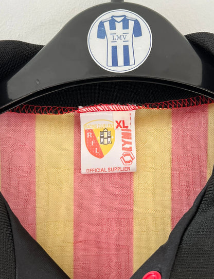 Maillot de foot vintage domicile rouge et jaune du RC Lens de la saison 1995/1996. On peut retrouver l'équipementier Olympic et le sponsor Shopi. Il s'agit d'un maillot authentique d'époque.