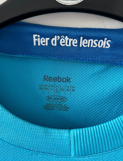 Maillot de foot vintage extérieur bleu du RC Lens 2009/2010. On peut retrouver l'équipementier Reebok et le sponsor Invicta. Il s'agit d'un maillot authentique d'époque.