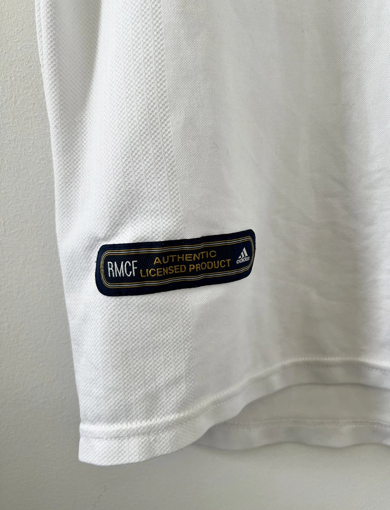 Maillot de foot vintage domicile du real madrid de la saison 2001-2002. Le maillot est de couleur blanc et noir. On peut retrouver l'équipementier adidas et le sponsor Real Madrid.com. Le maillot est floqué du numéro 5 Zinedine Zidane. Il s'agit d'un maillot authentique