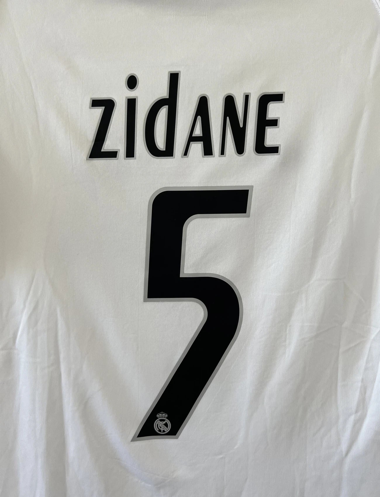 Maillot de foot vintage domicile du Real Madrid de la saison 2005/2006. Le maillot est de couleur blanc et noir. On peut retrouver l'équipementier adidas et le sponsor siemens. Le maillot est floqué du numéro 5 Zinedine Zidane. Le maillot possède l'étiquette d'authenticité avec les numéros 109879. Il s'agit d'un maillot authentique d'époque.