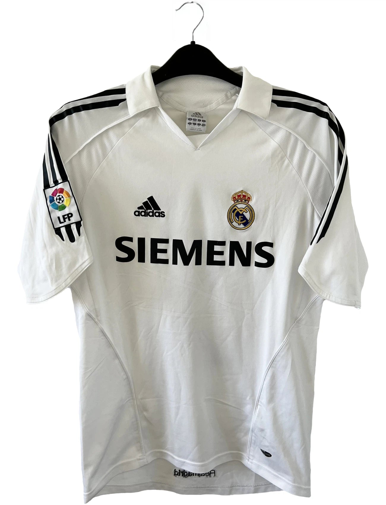 Maillot de foot vintage domicile du Real Madrid de la saison 2005/2006. Le maillot est de couleur blanc et noir. On peut retrouver l'équipementier adidas et le sponsor siemens. Le maillot est floqué du numéro 5 Zinedine Zidane. Le maillot possède l'étiquette d'authenticité avec les numéros 109879. Il s'agit d'un maillot authentique d'époque.