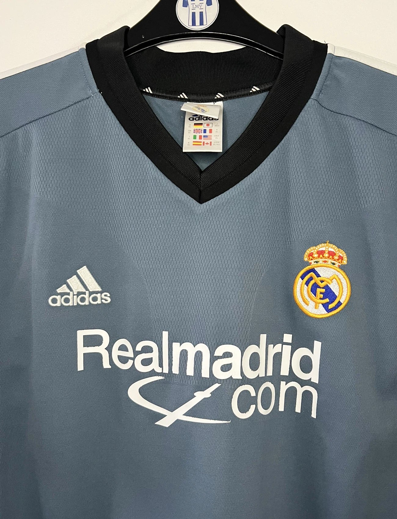 Maillot de foot vintage third gris du real madrid de la saison 2001-2002. On peut retrouver l'équipementier Adidas et le sponsor RealMadrid.com. Le maillot est floqué du numéro 5 Zinedine Zidane. Il s'agit d'un maillot authentique d'époque.